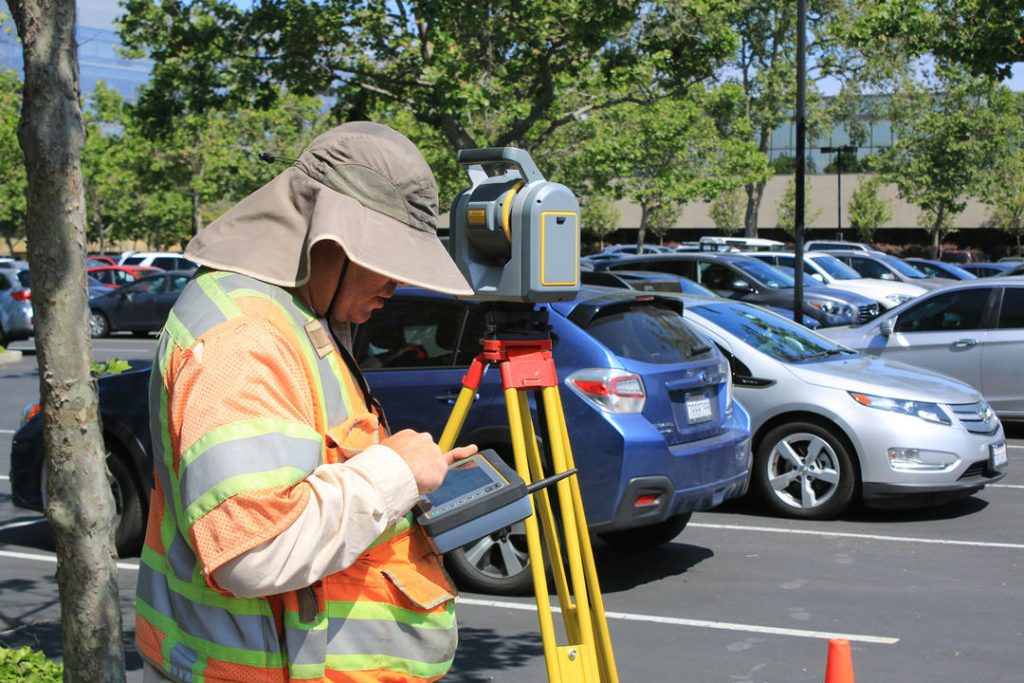 Land surveyor with survey equipment on the street